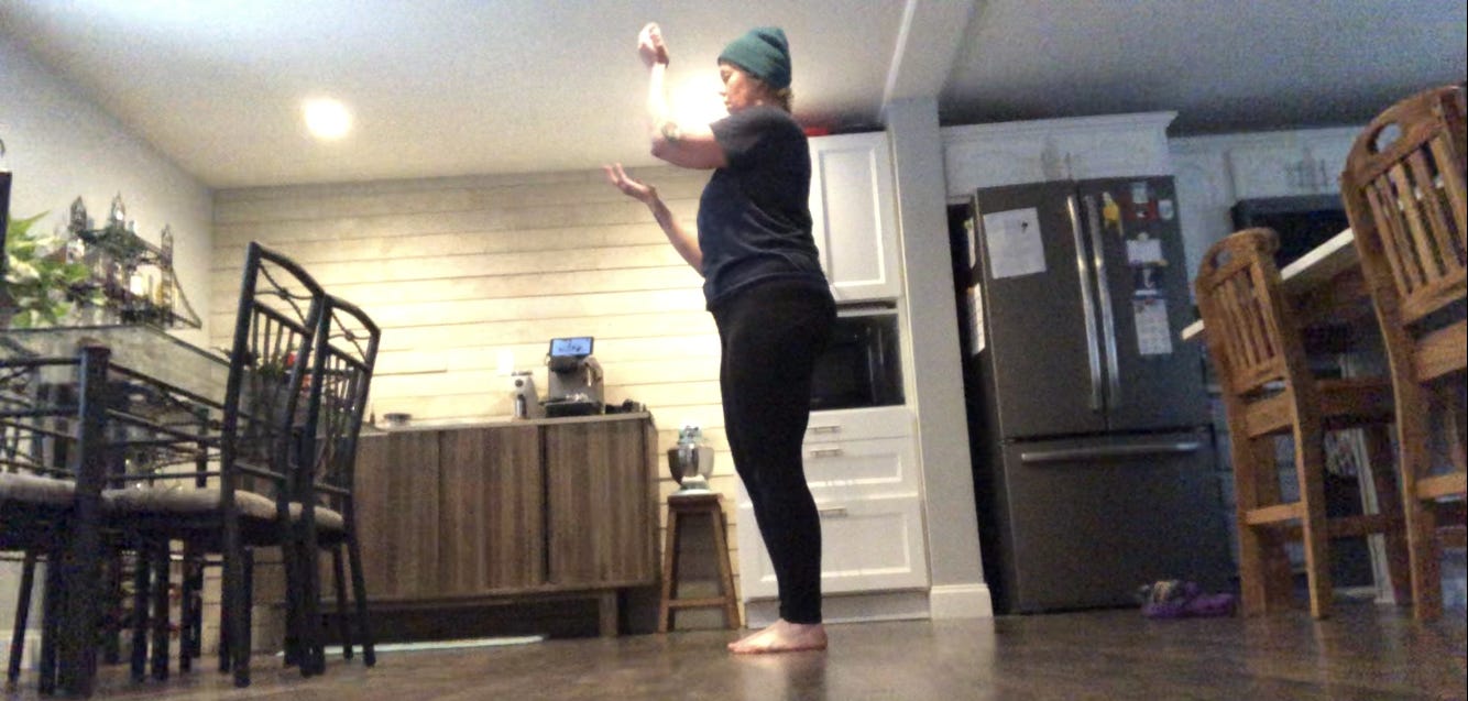 A person dances in a kitchen.