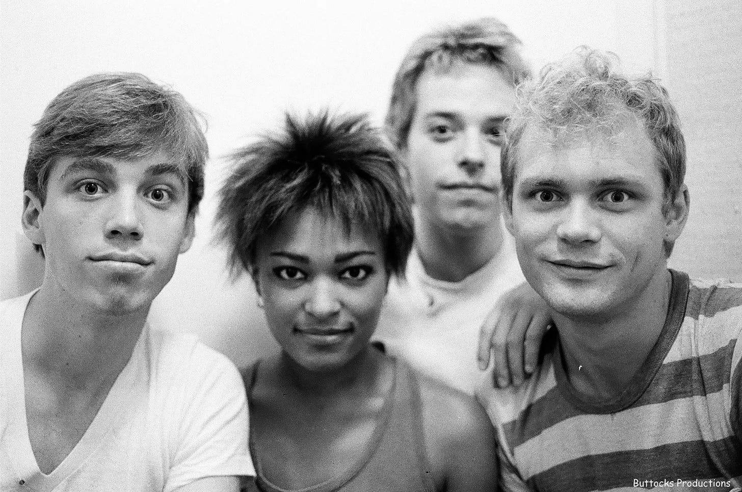 Black and white band photo of Bam Bam in front of a blank wall.