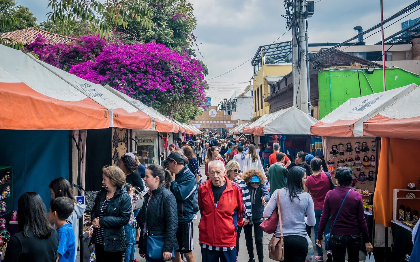 Crowd of people at festival shopping at pop up tent booths.