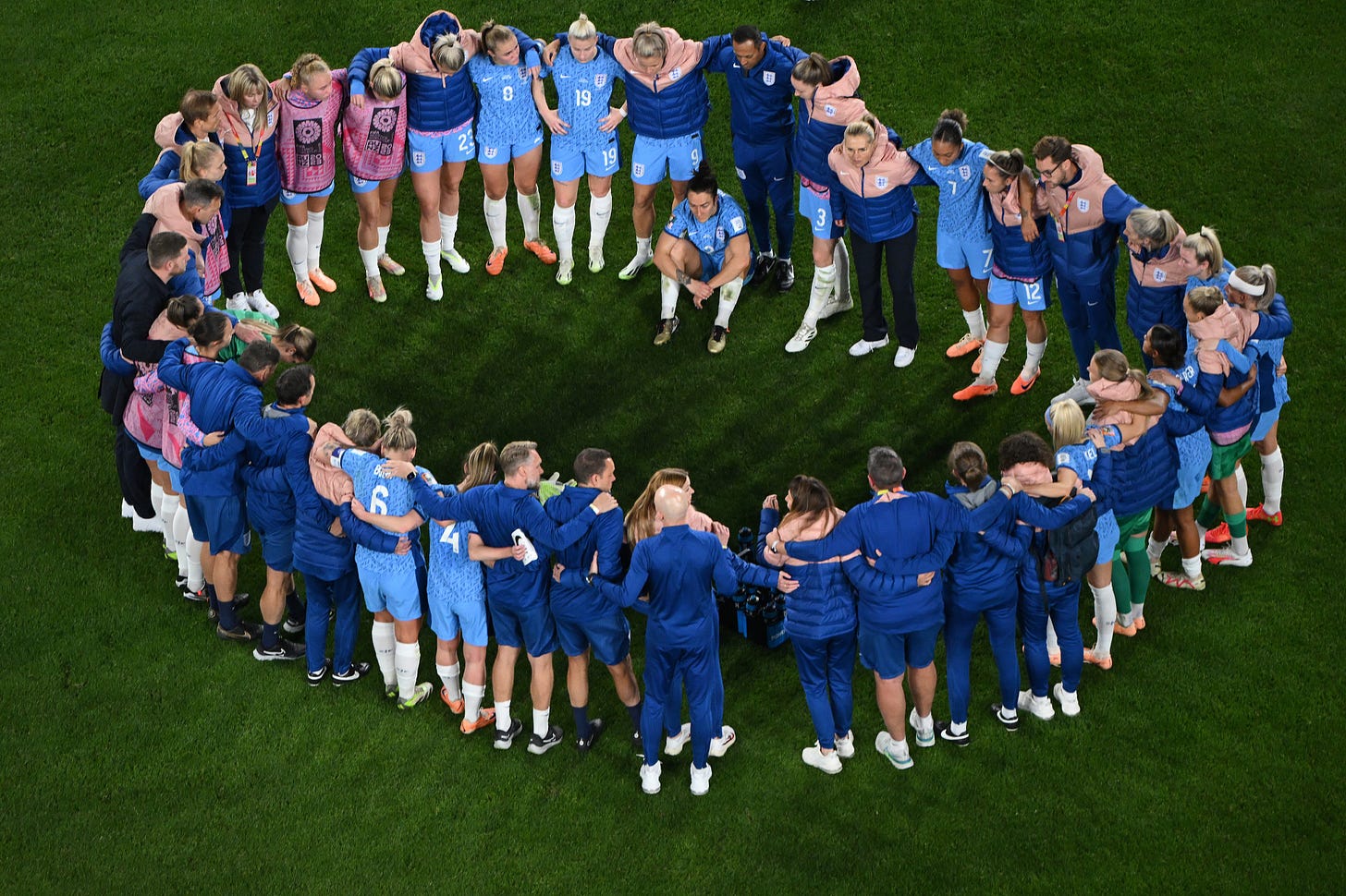 The England players and staff huddle after the game.