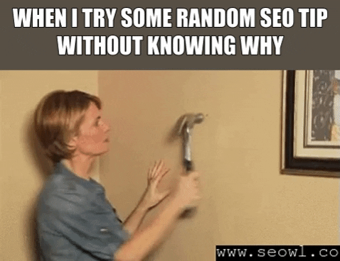 GIF of a woman cluelessly hammering a wall with the caption 'When I try some random SEO tip without knowing why'—relatable chaos for indie writers learning marketing on the fly.