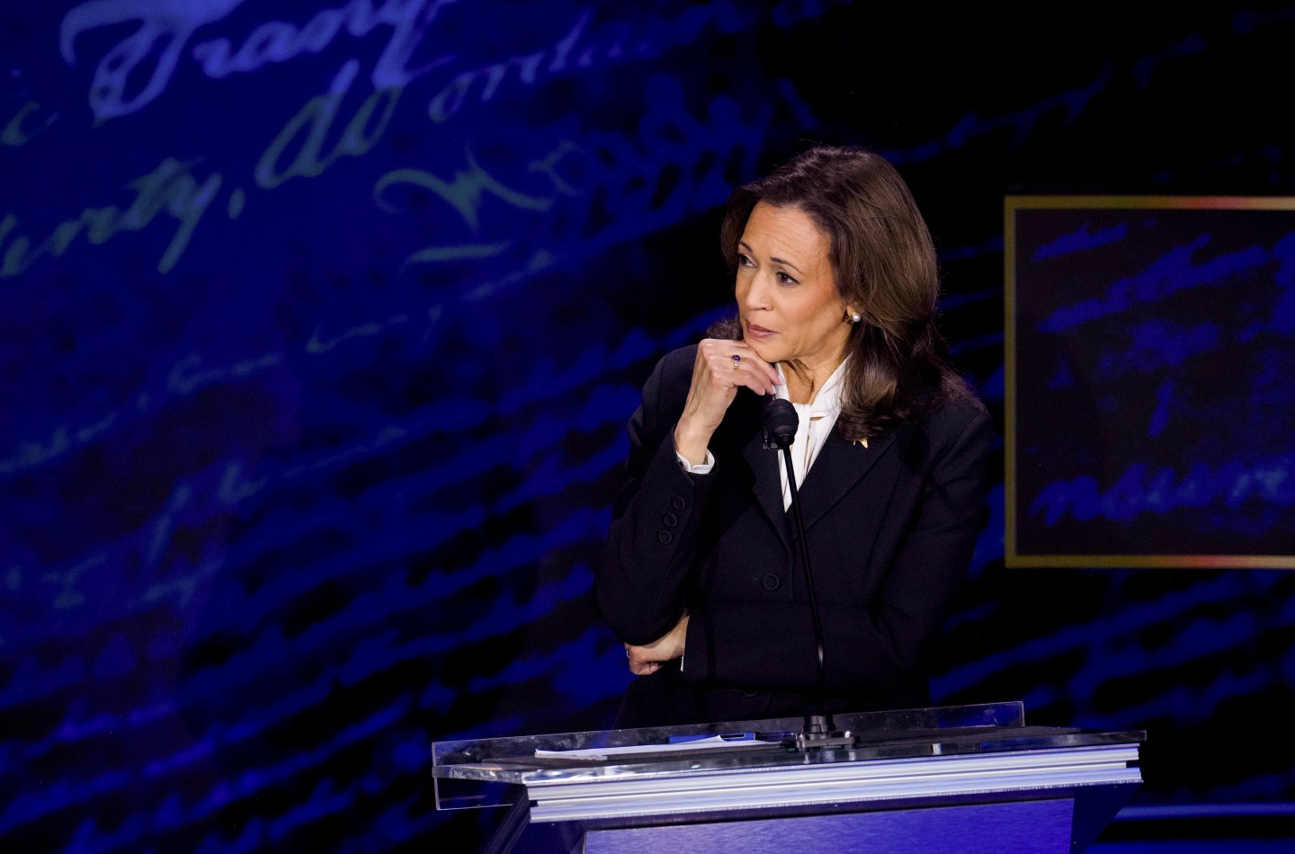 Kamala Harris holds her hand to her chin as she listens to Trump talk during their presidential debate. 