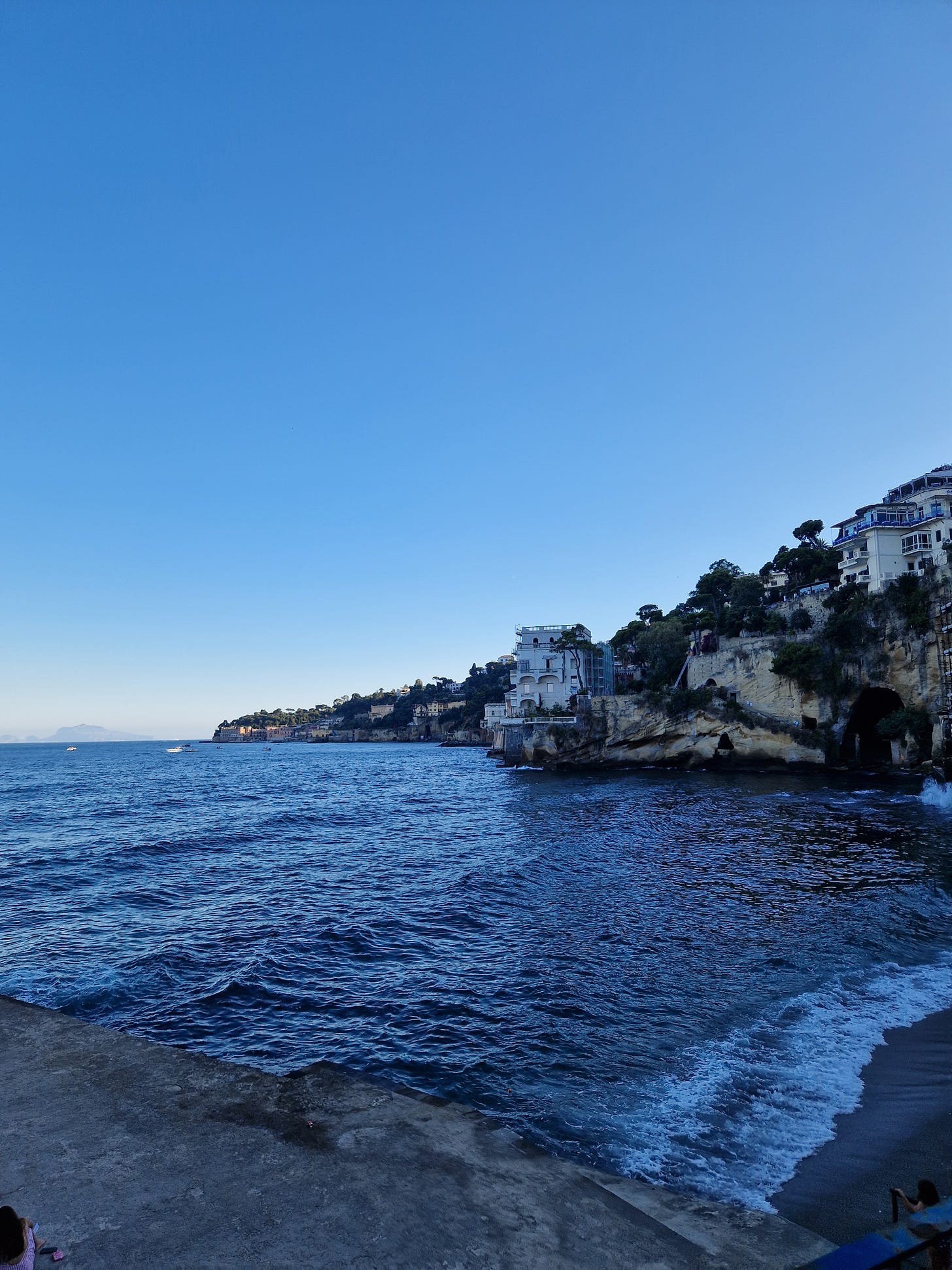 View of an bay, surrounded by buildings built into a cliff side.