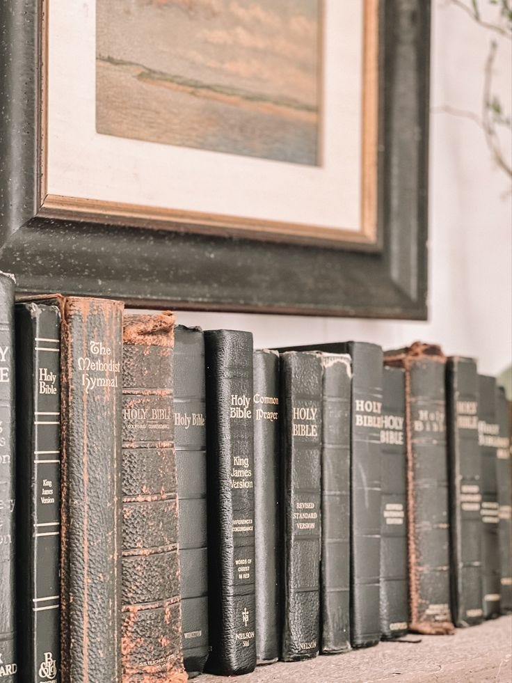 This may contain: old books are lined up on the mantle in front of a framed painting and tree