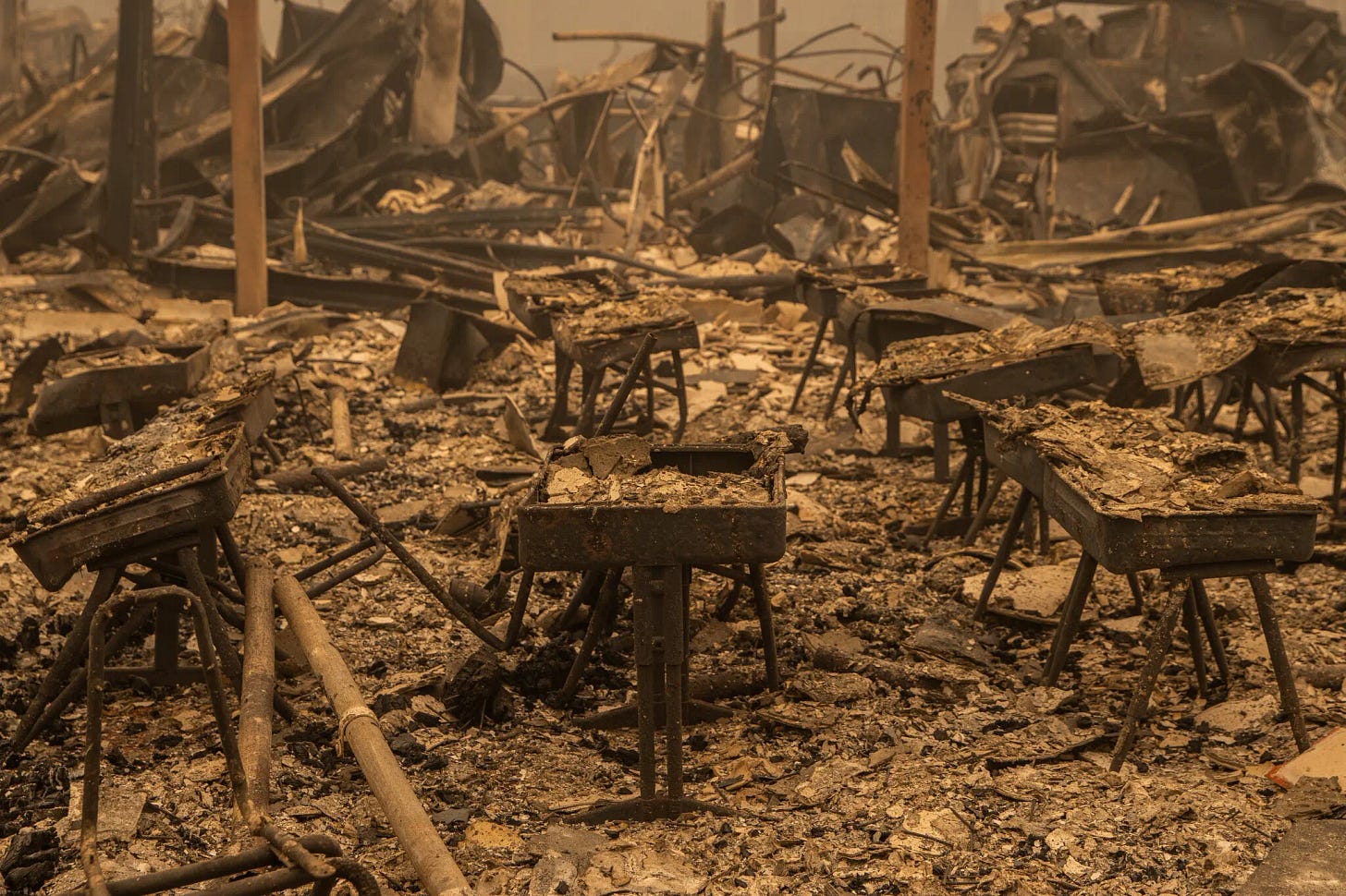 Burned desks in the remains of the Berry Creek Elementary School, which was consumed by flames along with most of the town last week.Credit...Max Whittaker for The New York Times