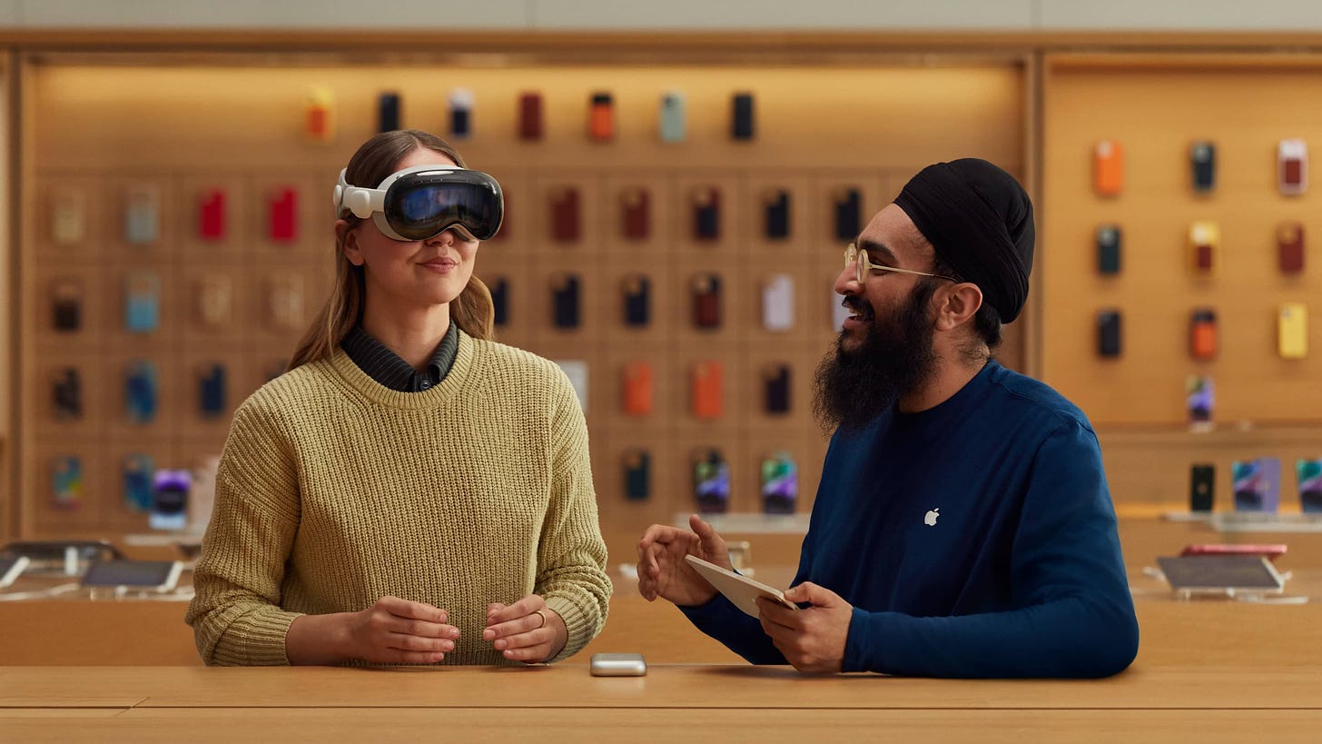 A Specialist guides a customer through the Apple Vision Pro experience while seated at an Apple Store.