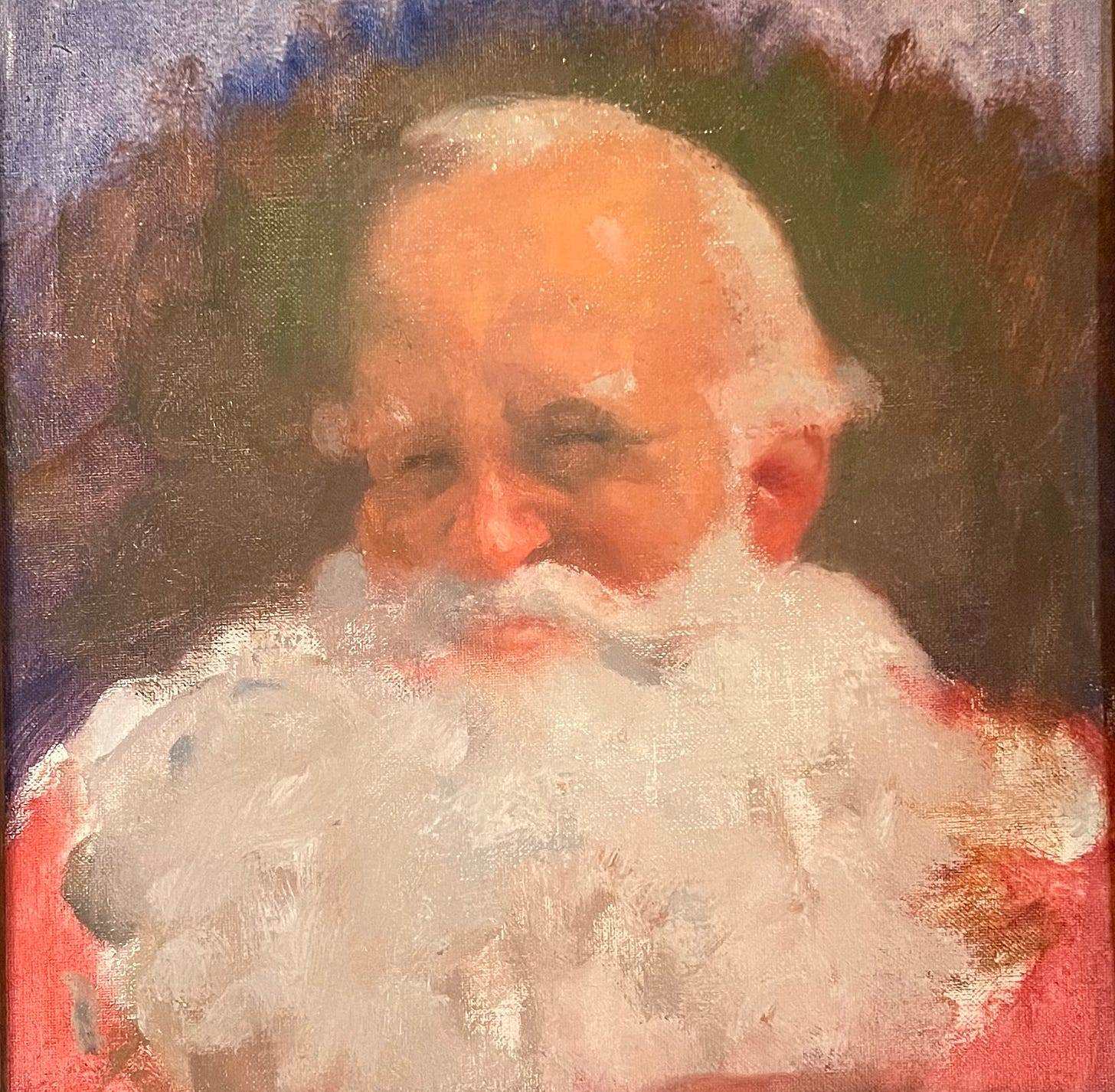 Portrait of the head of Santa, smiling, white curly beard spread across chest.