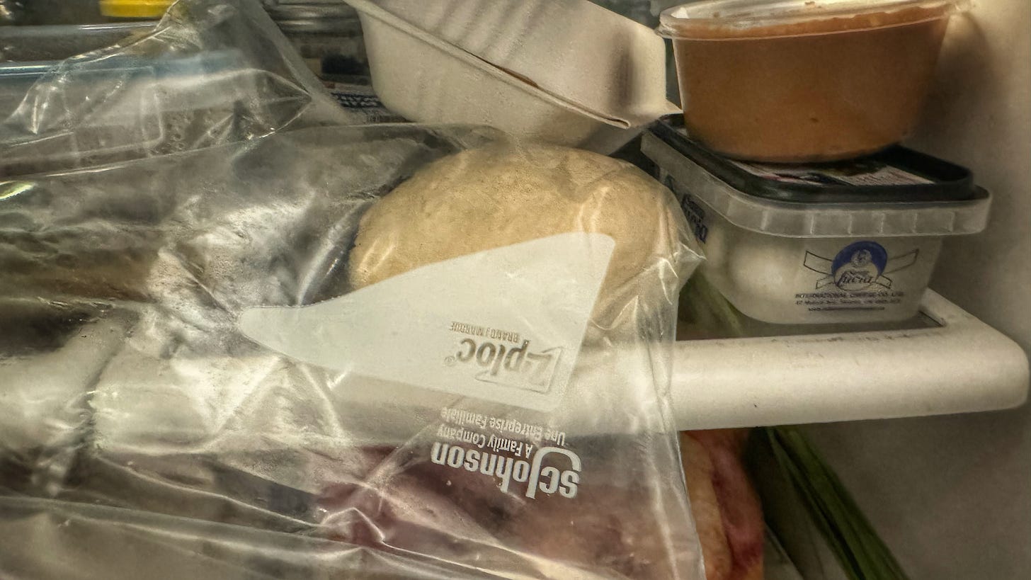A ziploc bag containing our dough ball in a fridge that is crowded with so many other things. Space is at a premium.