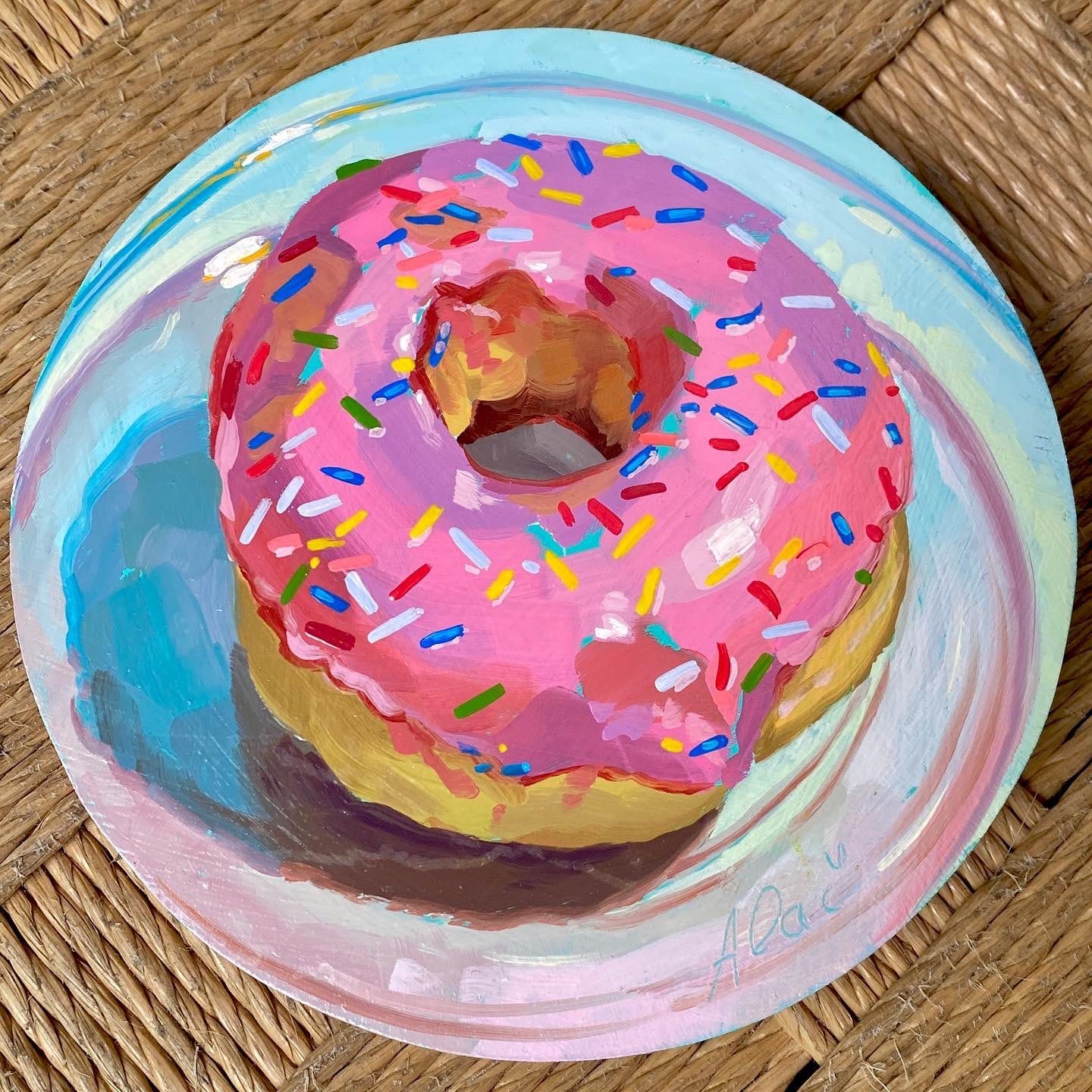 pintura a óleo de um donnut com cobertura rosa e confeitos coloridos em cima de um pratinho branco