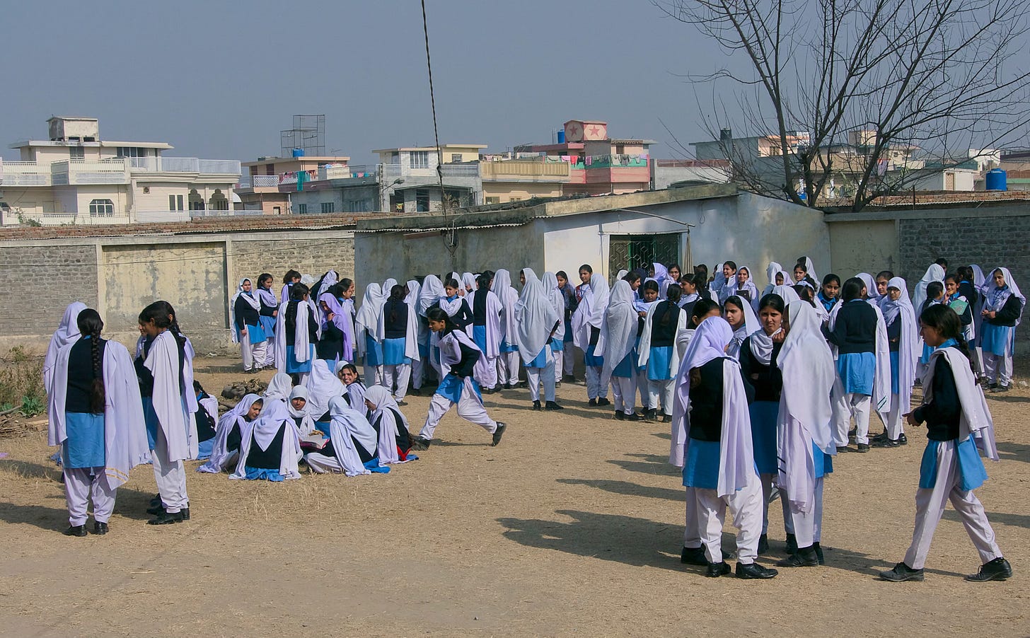 Pakistani girls in lilac gather outside a school in Islamabad 