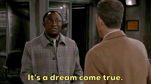 GIF of a black man facing a white man saying ''it's a dream come true"