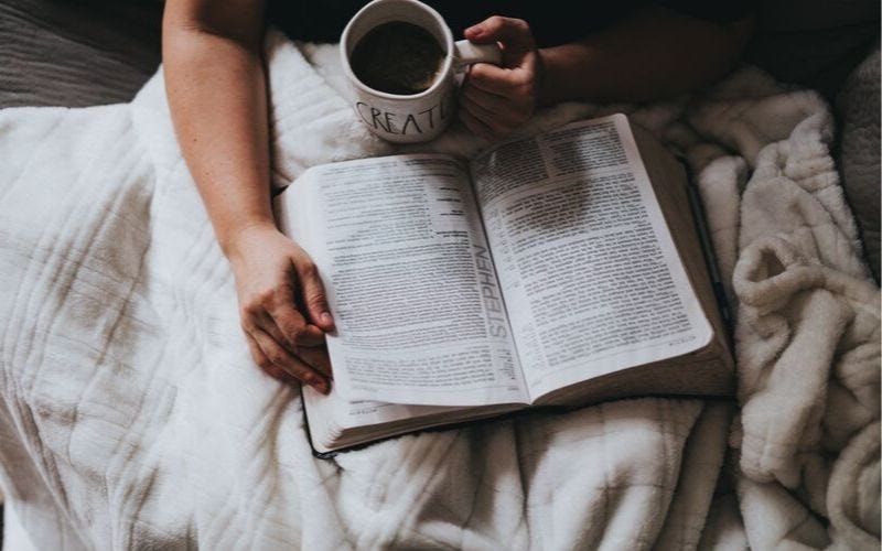 woman reading bible and drinking coffee