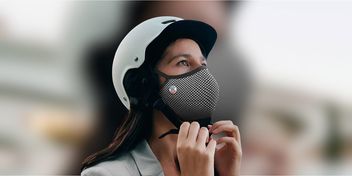 Jeune femme portant un casque et un masque antipollution