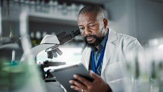 A man sitting at a microscope