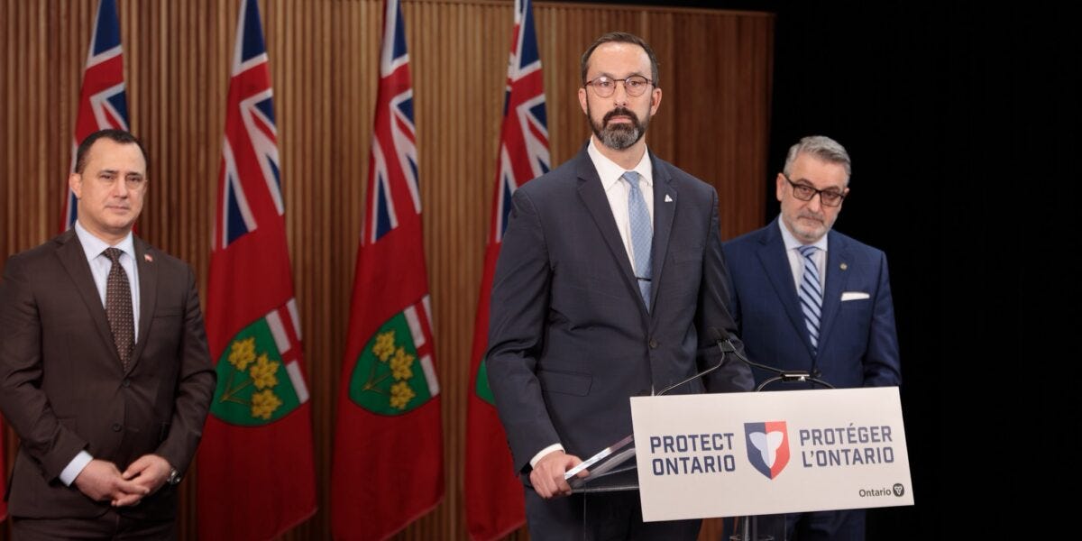 Minister of Colleges and University Nolan Quinn speaks at the announcement of Bill 33 with Minister for Education Paul Calandra standing behind him to his right.