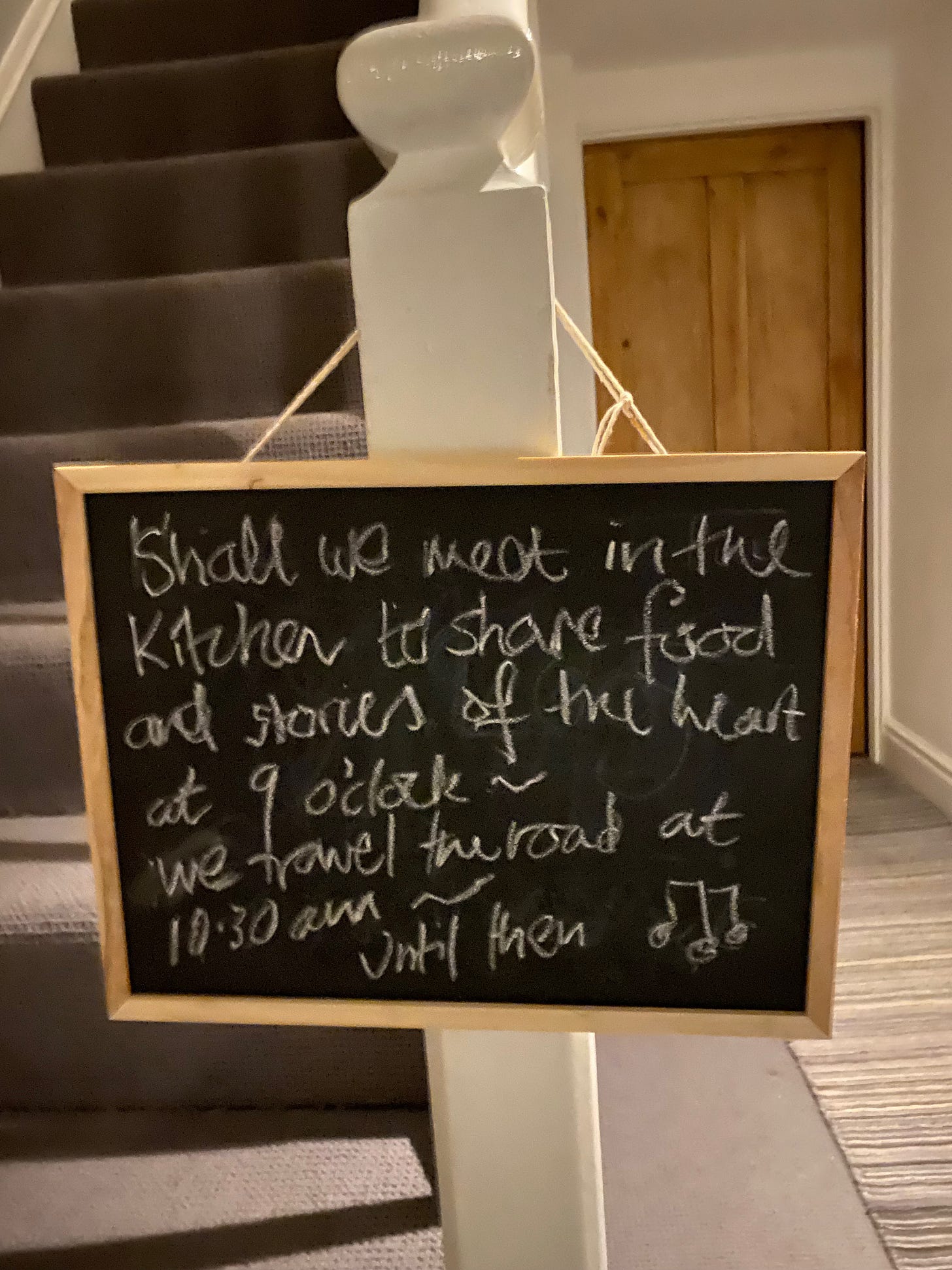 Picture of a chalkboard with Starlite's poem "Shall we meet to share food and stories of the heart at 9 o'clock. We travel the road at 10:30 am - until then"