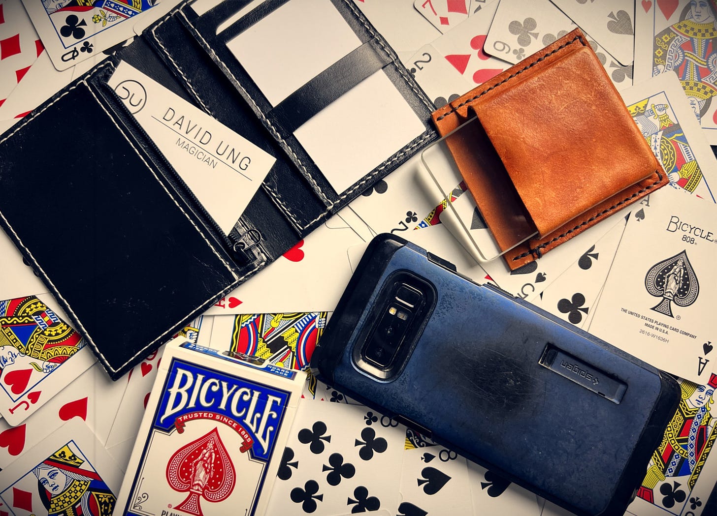 A wallet, omni deck, switcheroo, phone and deck of cards