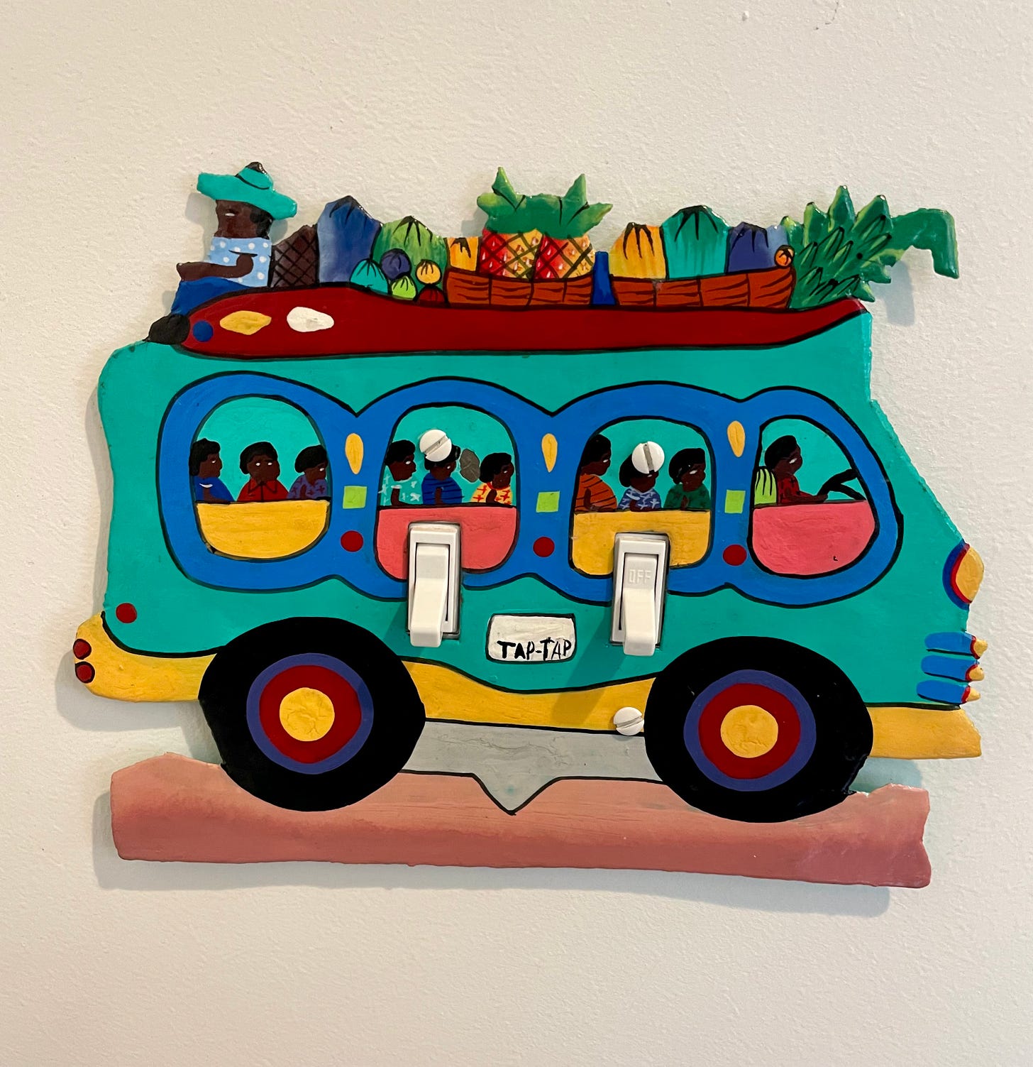 A steel drum taxi van light switch cover made in Haiti.