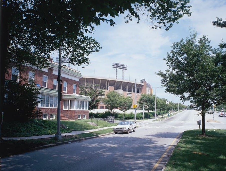 Photograph of Baltimore’s Memorial Stadium, taken from a tree-lined street.