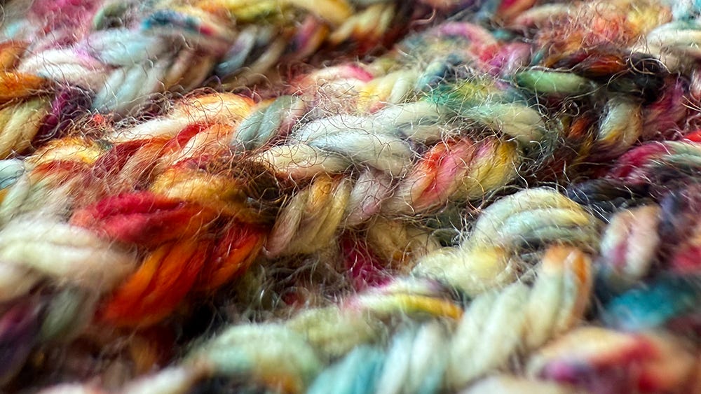 Close-up view of multicolored yarn in a knitted pattern.