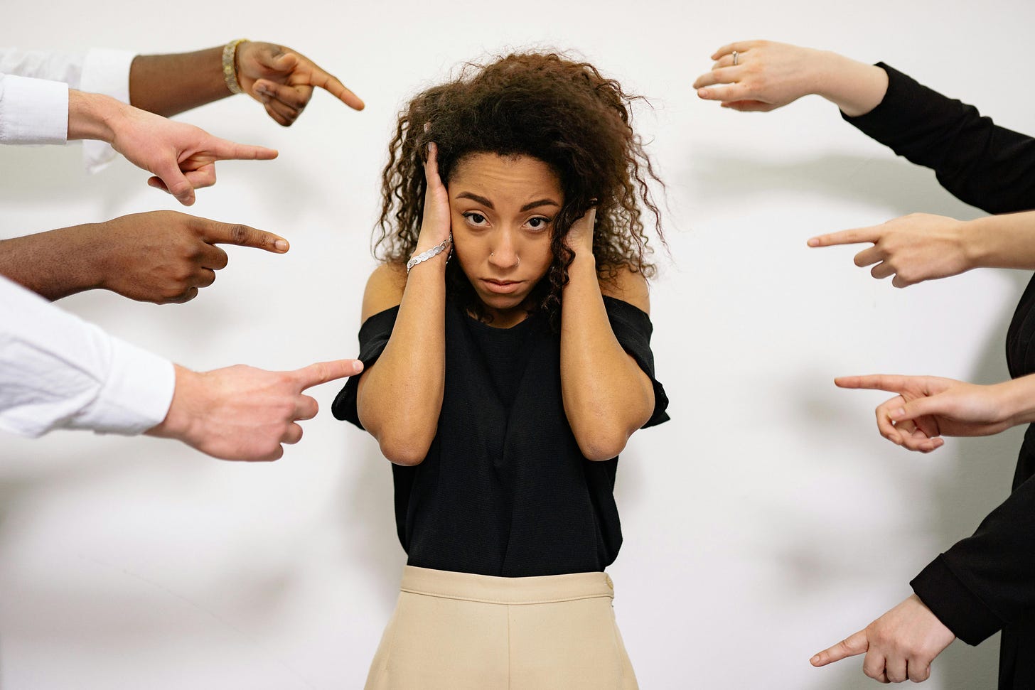 People pointing fingers at a stressed woman