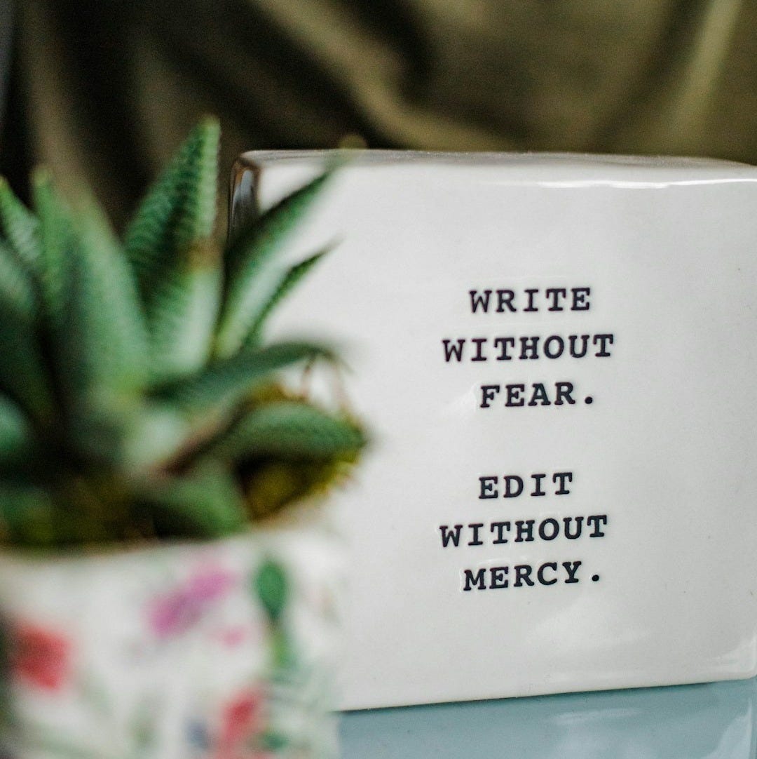 a white box with writing on it next to a plant