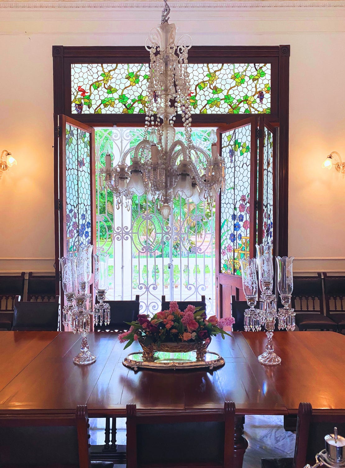 The dining room in La Quinta Montes Molina, Merida, showing its elaborate chandelier and stained glass windows.