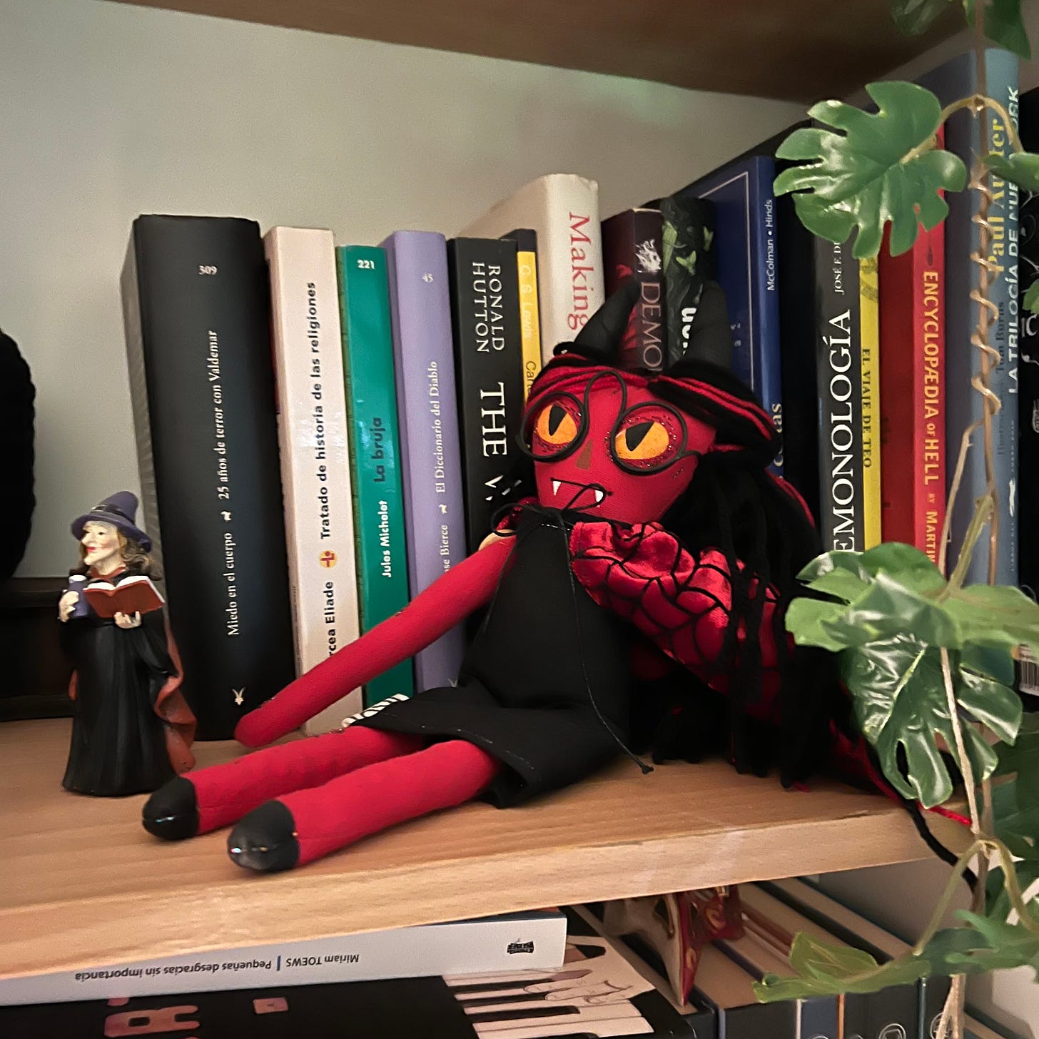 El libro Hacer el mal detrás de una muñeca que representa un demonio.