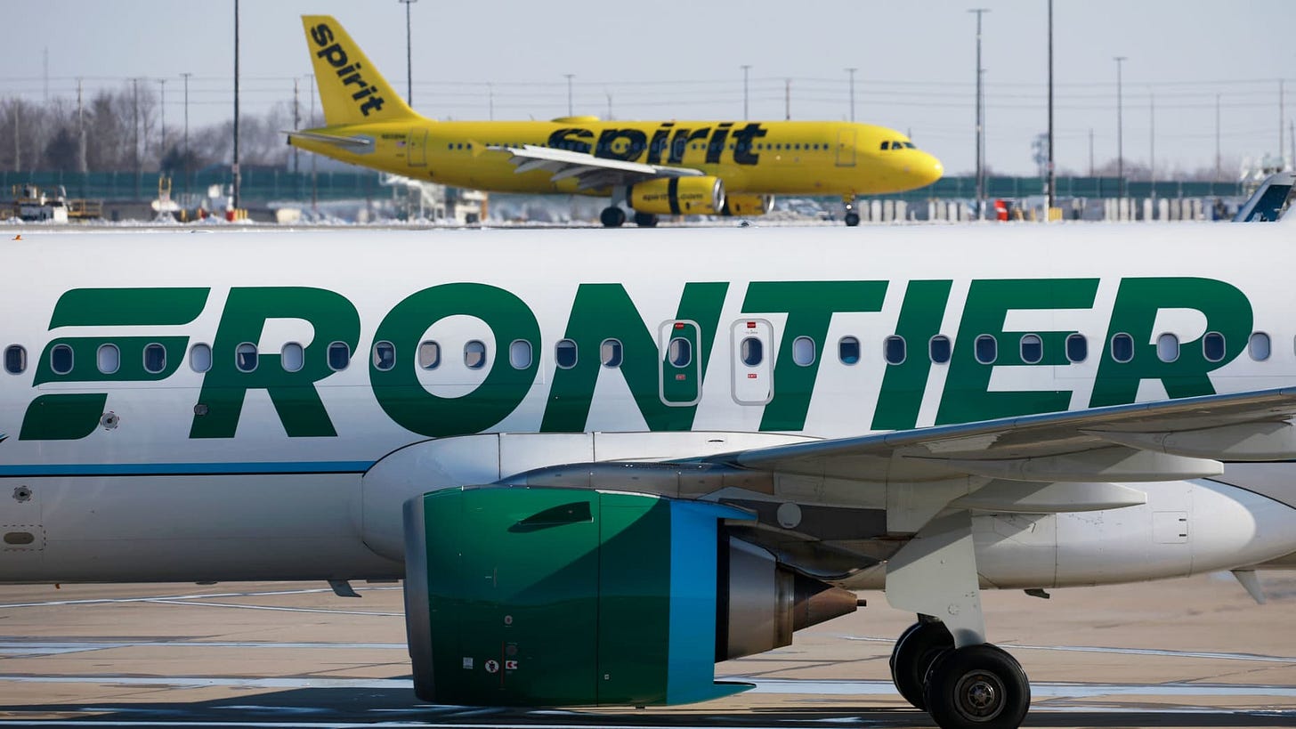 A Frontier Airlines airplane taxis past a Spirit Airlines aircraft at Indianapolis International Airport in Indianapolis, Indiana, on Monday, Feb. 7, 2022.