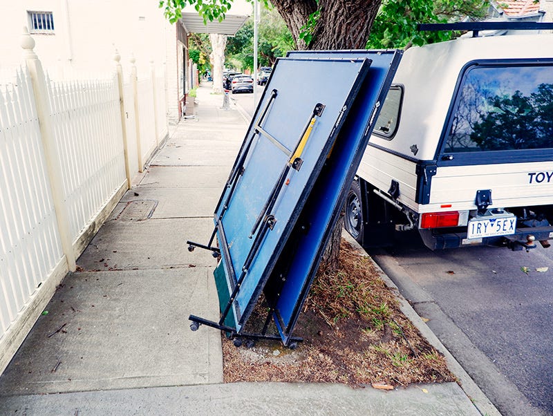 A table tennis table left out in hard rubbish.