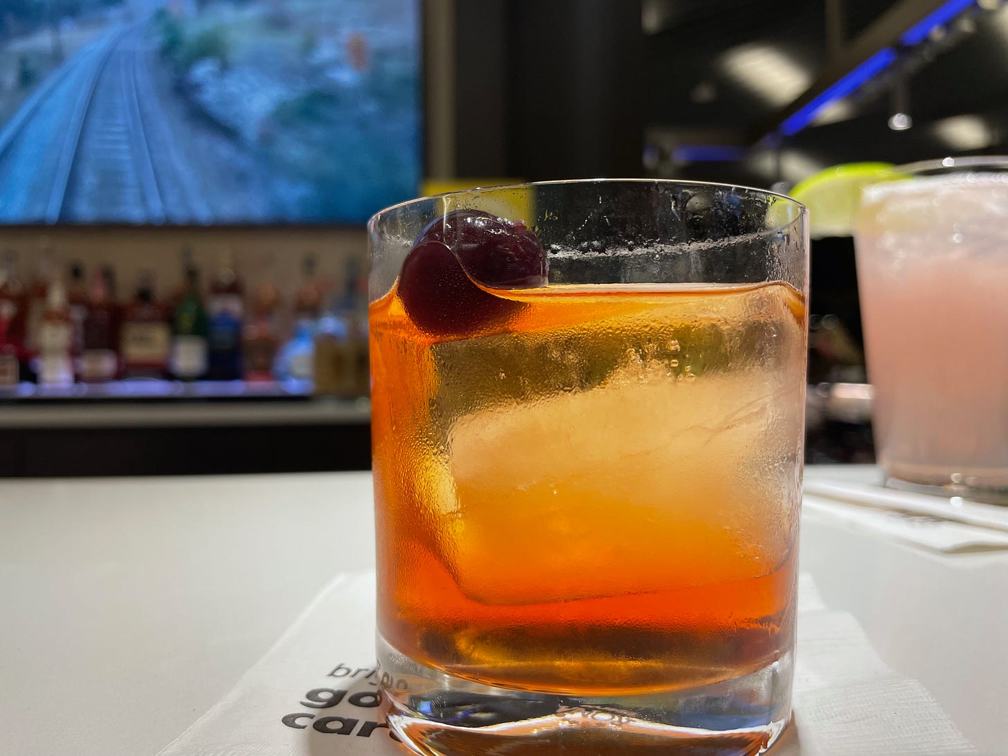 Old-Fashioned in a glass with a cherry floating on top.