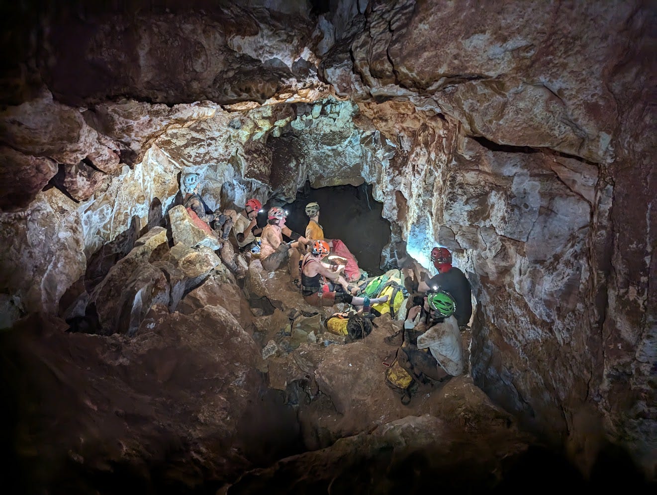 7 cavers sitting on a breakdown pile in large passage