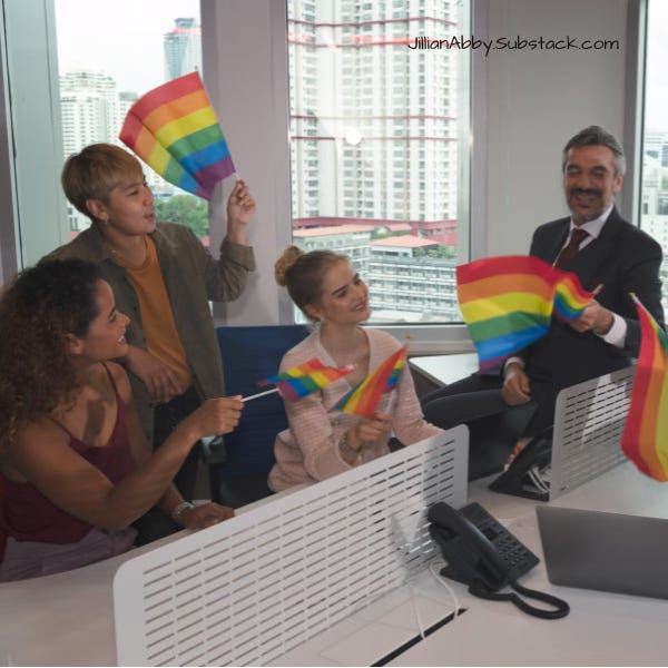 Several people in business attire inside of an office, waving LGBTQ Pride flags.