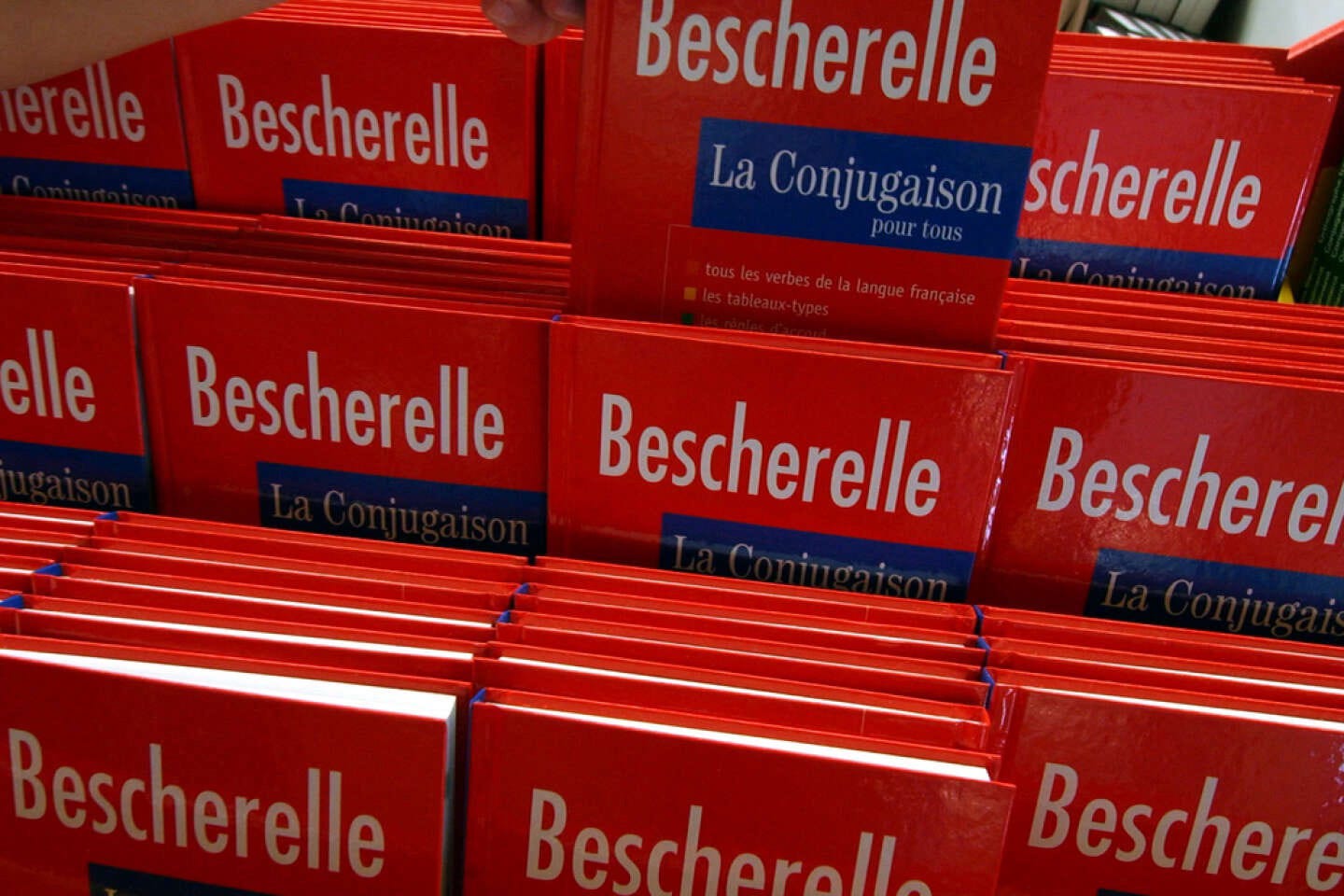 A bookshop display full of bright red Bescherelle French grammar books.
