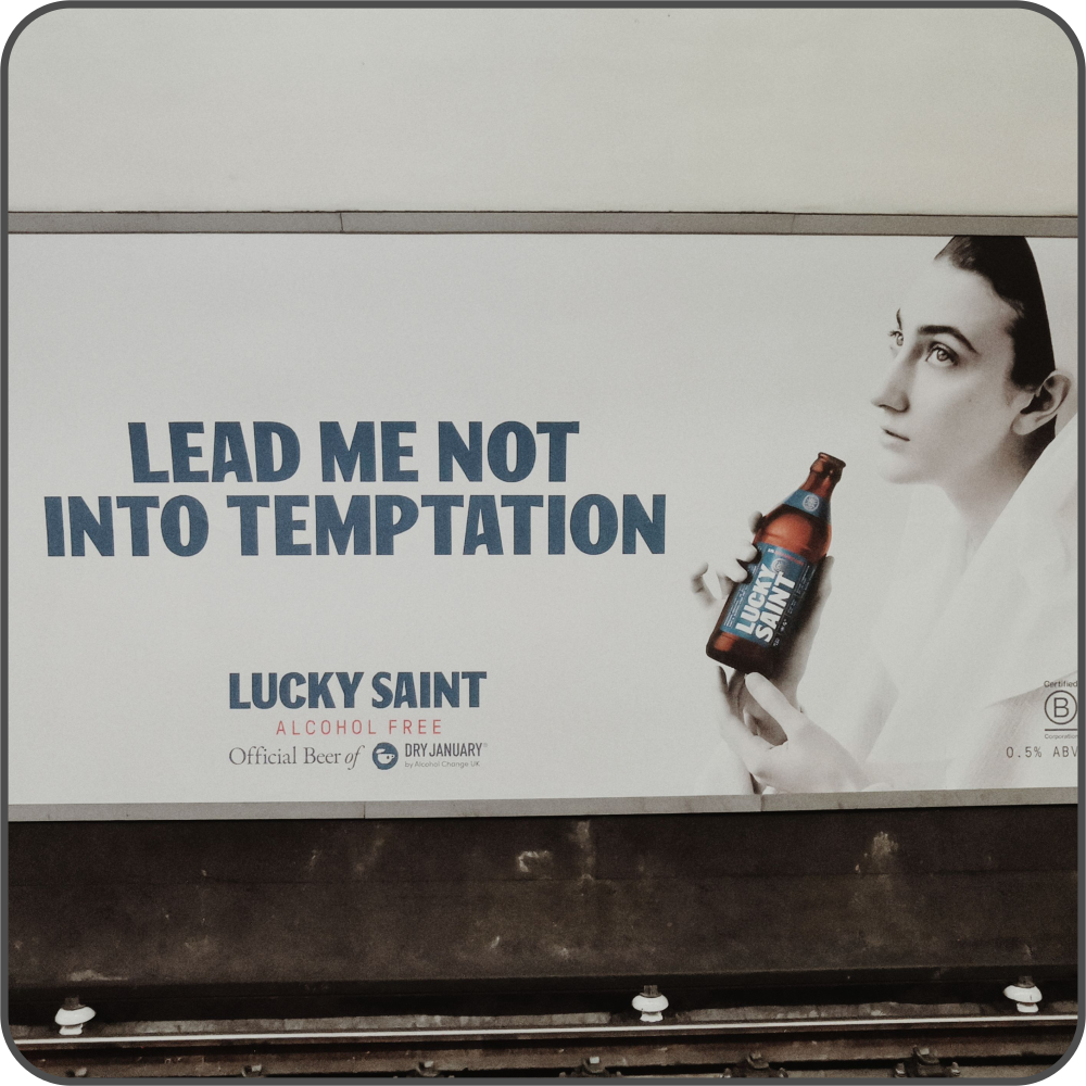 A billboard with the tagline 'lead me not into temptation', with a nun holding a bottle of alcohol-free beer