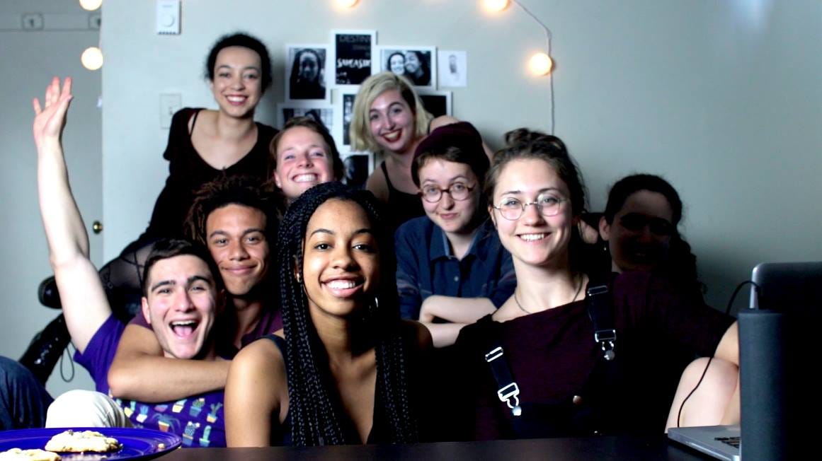 The cast and crew of the Middlemarch web series pose in a brightly-lit living room. The series director, Rebecca Shoptaw, awkwardly perches on the couch in the back. The cast and crew of the Middlemarch web series pose in a brightly-lit living room. The series director, Rebecca Shoptaw, awkwardly perches on the couch in the back.