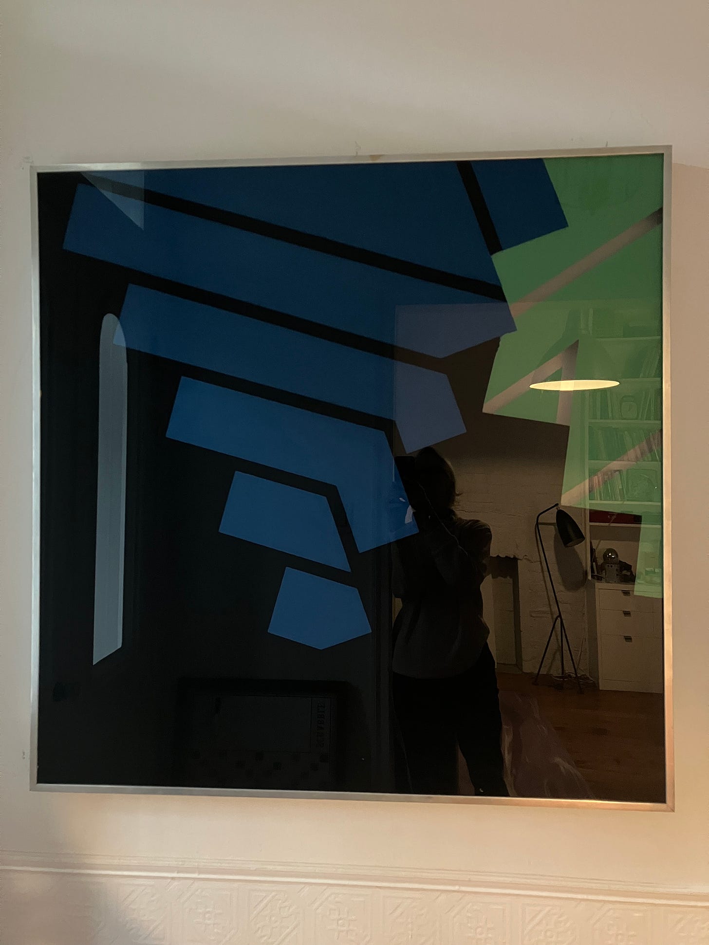 photograph of framed abstract work on plexiglas by Earle Olsen. Blue and green geometric forms overlap.