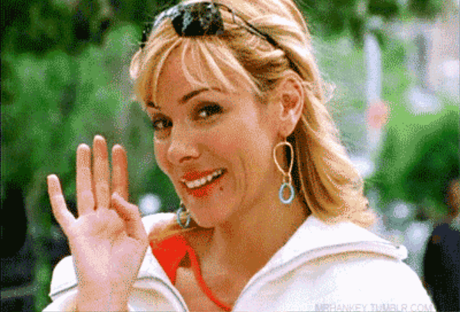 Kim Cattrall, nei panni di Samantha Jones. Sorride e saluta.