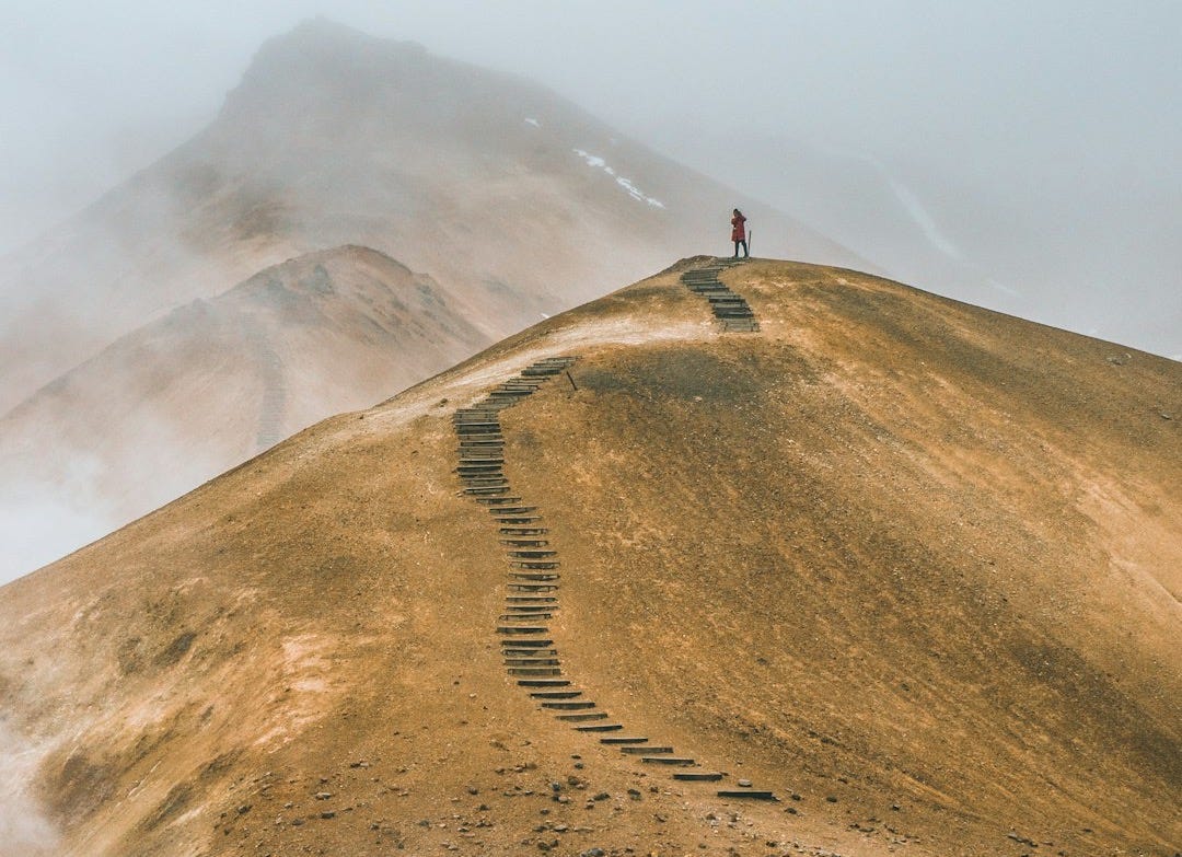 man on top brown hill