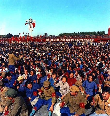 Crowds of young Chinese citizens wearing paramilitary outfits with red arm bands 