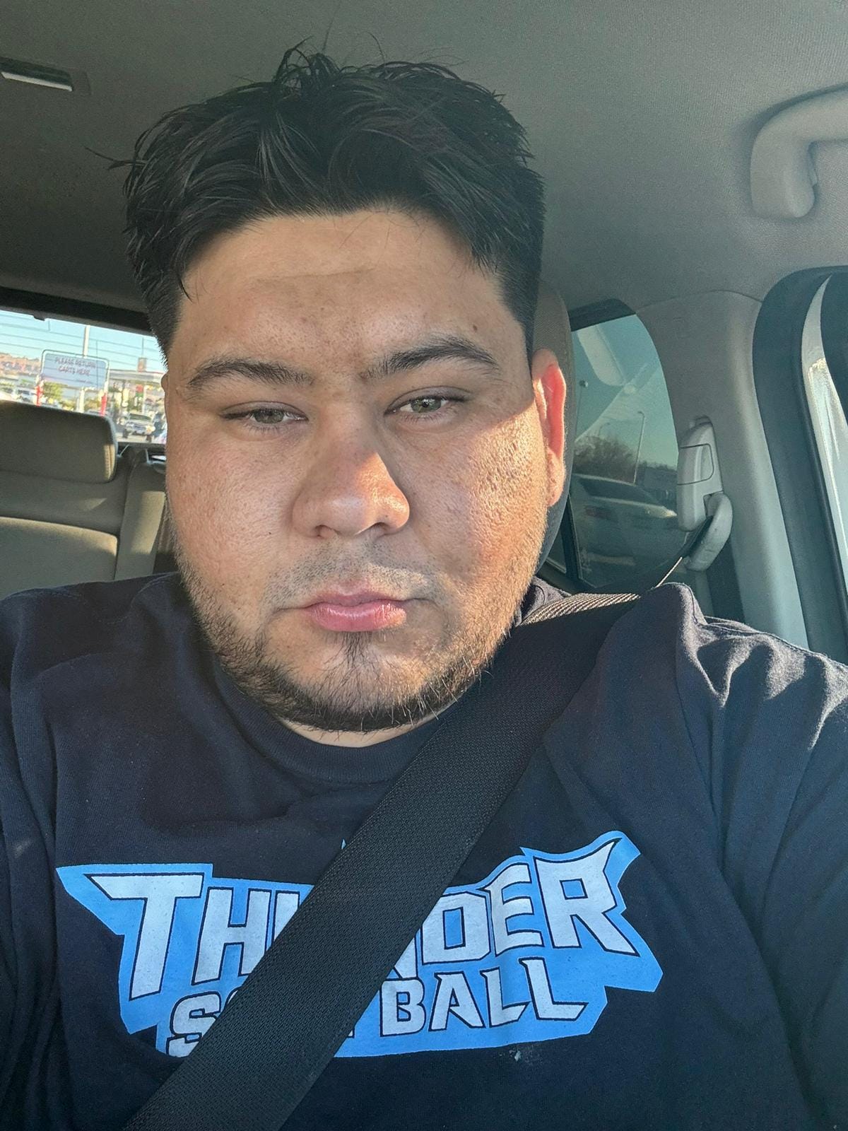 A man poses for a selfie inside a car A man poses for a selfie inside a car