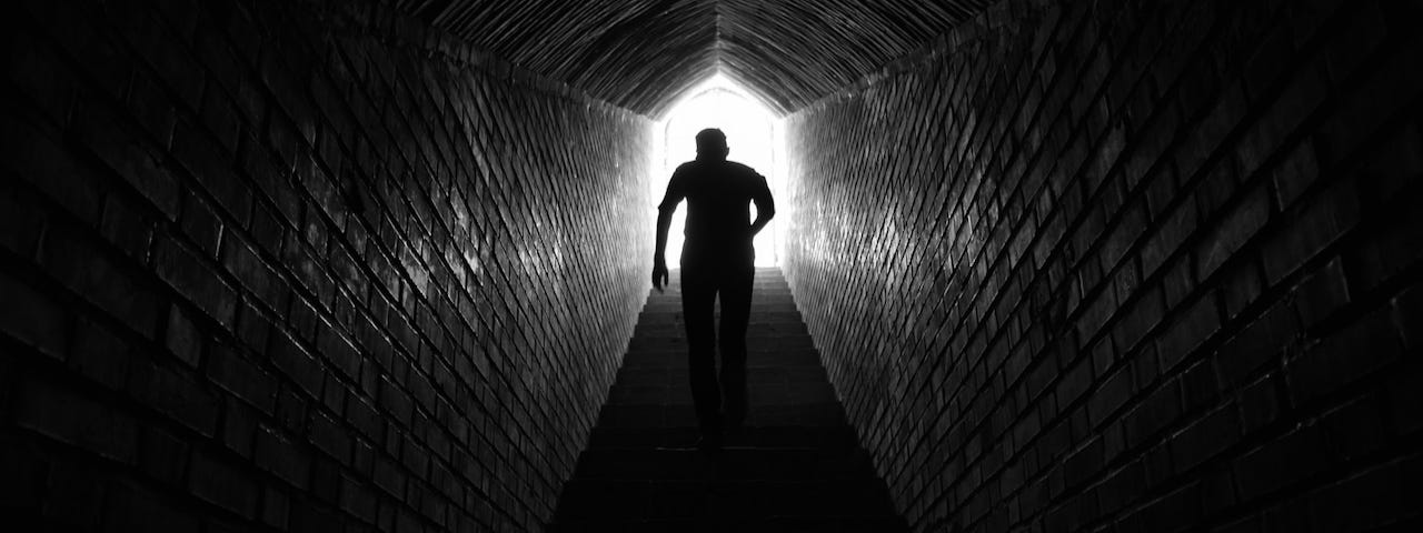 Man in tunnel crossing into the light