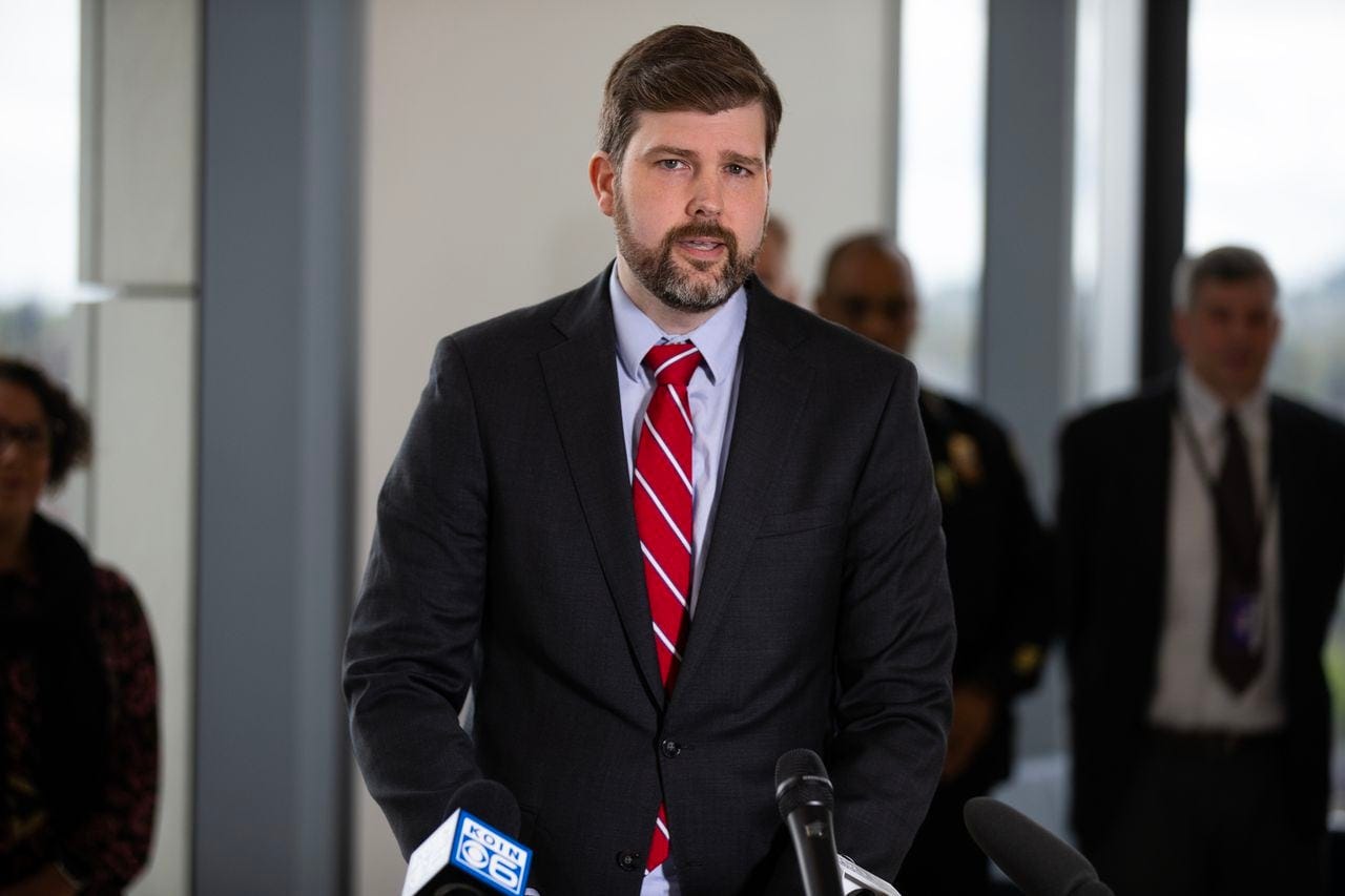 Multnomah County District Attorney Mike Schmidt speaks at a podium at a press conference