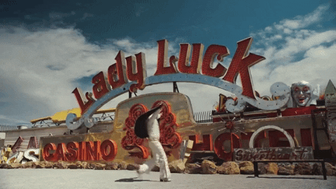 GIF: An Elvis in a white suite and cape dances in front of Lady Luck Casino