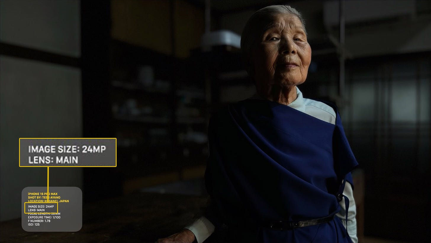 Low key photo of an old Japanese woman in a dark room looking at the camera.