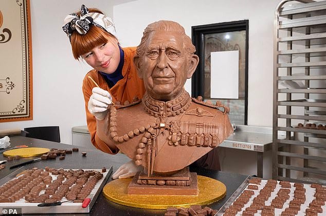 An expert team of chocolatiers and model makers studied hours of footage the King to capture his likeness, before melting down more than 17 litres of chocolate to inject into a bespoke mould. Pictured, Chocolatier Jennifer Lindsey-Clarke adds the finishing touches to bust of King Charles III made from Celebrations chocolates