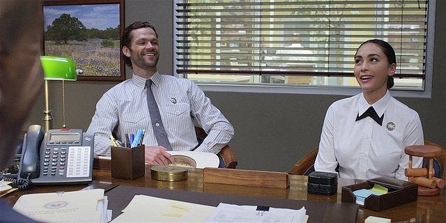 Walker Cordell and Micki laughing in sergeants office.