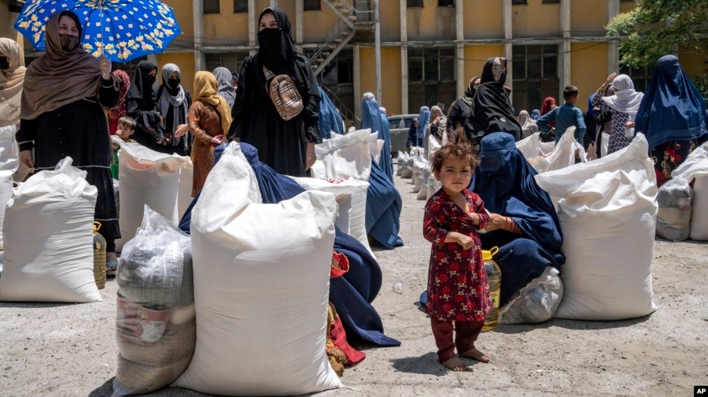 FILE - Afghan women receive food rations distributed by a humanitarian aid group, in Kabul, Afghanistan, May 28, 2023.