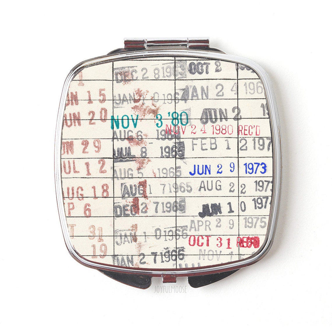 May include: A silver compact mirror with a vintage calendar design. The calendar dates are printed in red, blue, and black. The dates are from 1964 to 1980. The mirror is closed and the text 'JOYFULMOUSE' is printed on the bottom.
