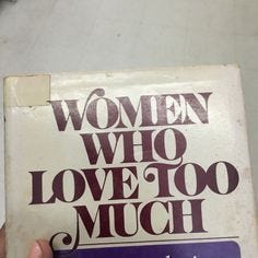 This may contain: a woman who love too much is holding up a book with the title written on it